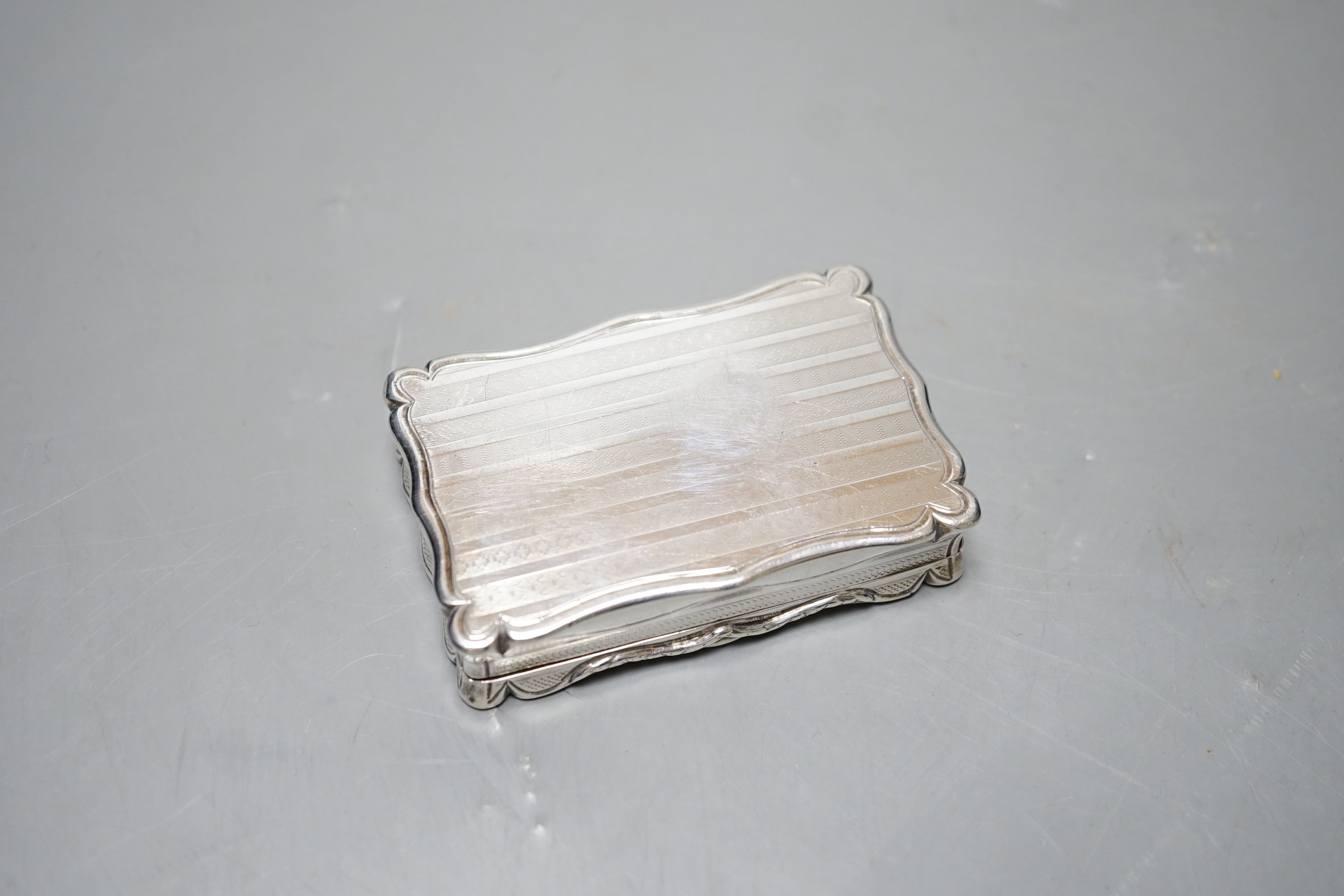A Victorian engine turned silver shaped rectangular snuff box, Edward Smith, Birmingham, 1847, 80mm, with interior engraved inscription.